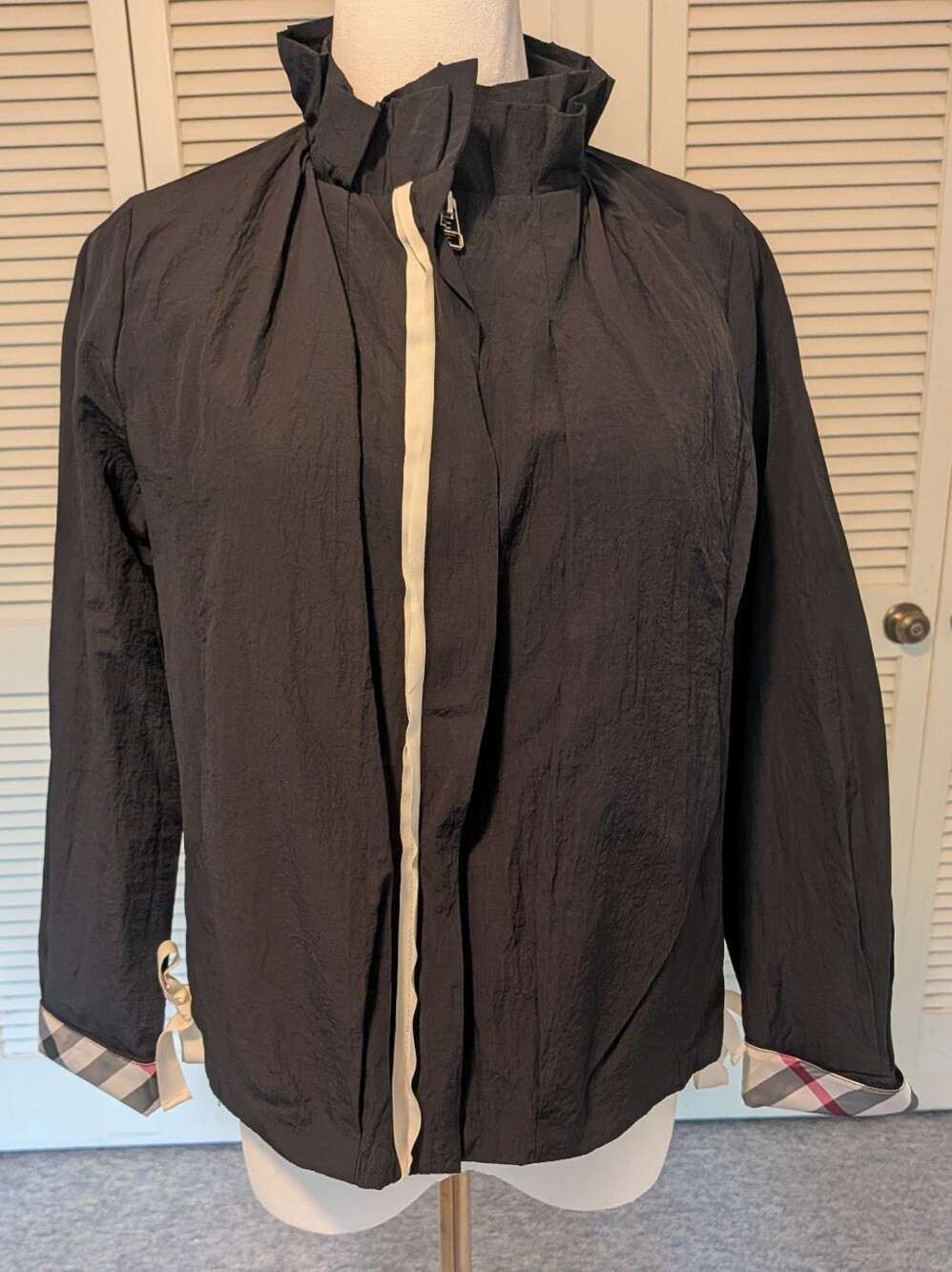 Joh. jacket. Black with plaid lining. Ribbon ties at sides.